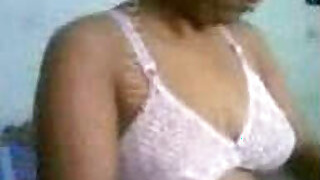 Busty girl Poorna in a pink bra changing in her bedroom